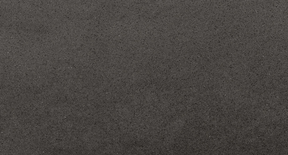Modern Manhattan Gray quartz slab showcasing a rich charcoal base with fine speckled texture, perfect for sleek countertops and contemporary surfaces. Manhattan Gray quartz slab with deep charcoal background and subtle speckled texture